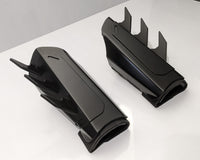 A pair of matte black protective armor metal batman bracers displayed on a clean white surface with a light gray background.