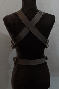 Mannequin wearing futuristic torso armor in black and grey with glowing red lights