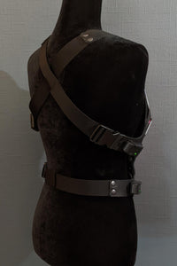 Mannequin wearing futuristic torso armor in black and grey with glowing red lights